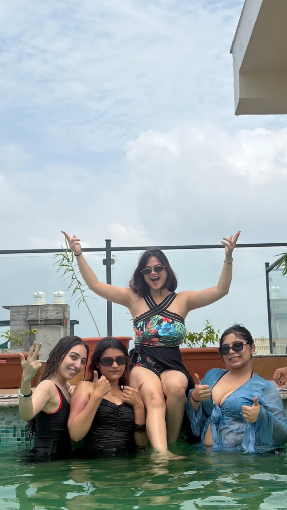 The group cheering together in a rooftop pool