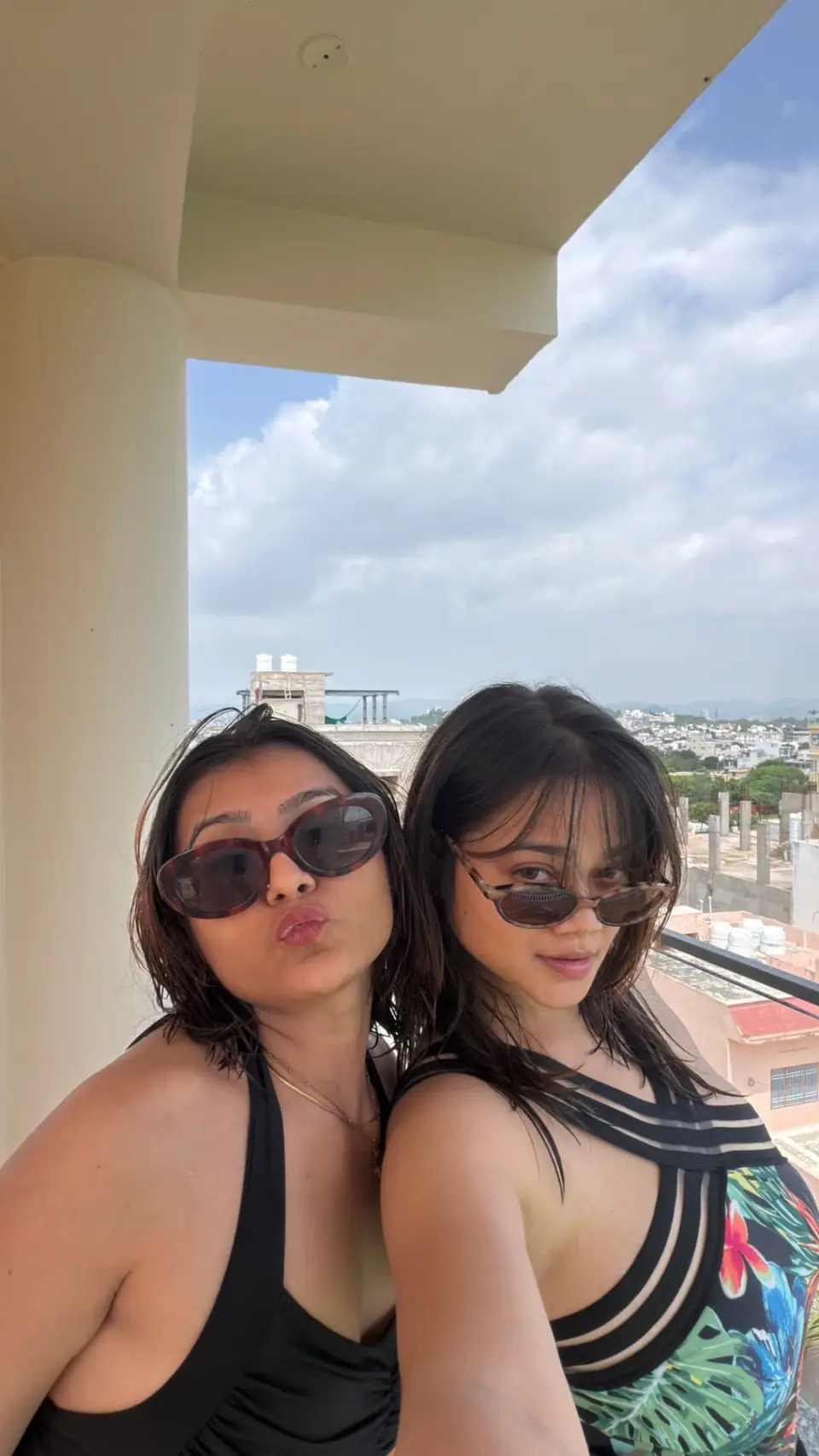 Two travellers on a balcony with the town behind them